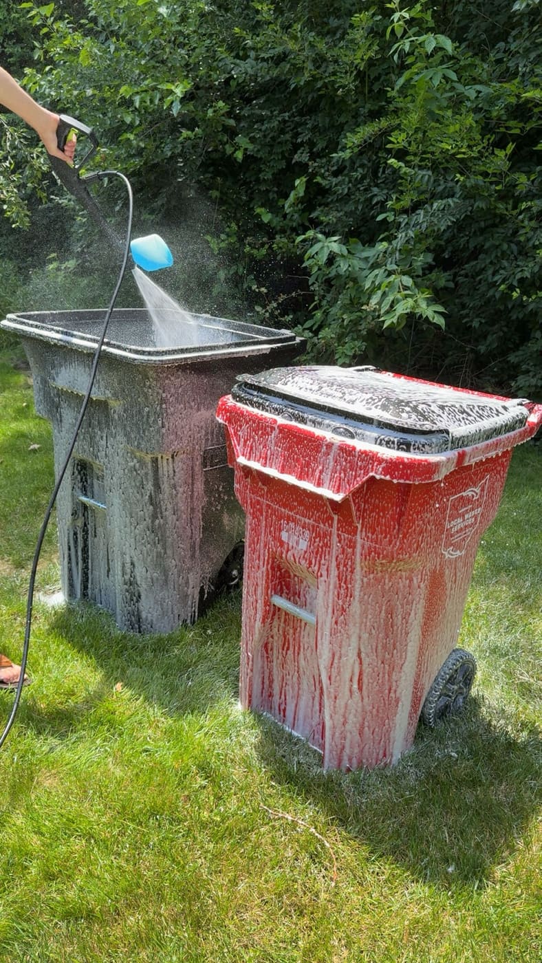 Buckeye Bins power-washing two curbside bins covered in foam